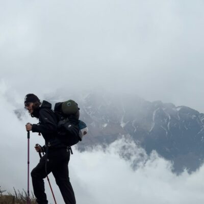 Trekker hiking in Mardi Himal with cloudy mountains in Nepal