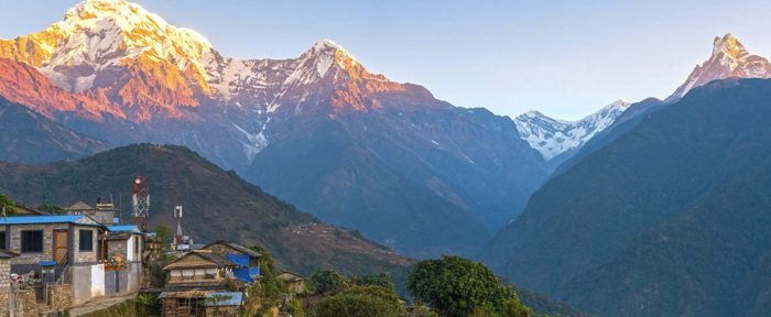 a mountain range with a house and trees