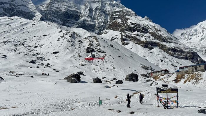 Helicopter rescue at Annapurna Base Camp with Himalayan peaks in background